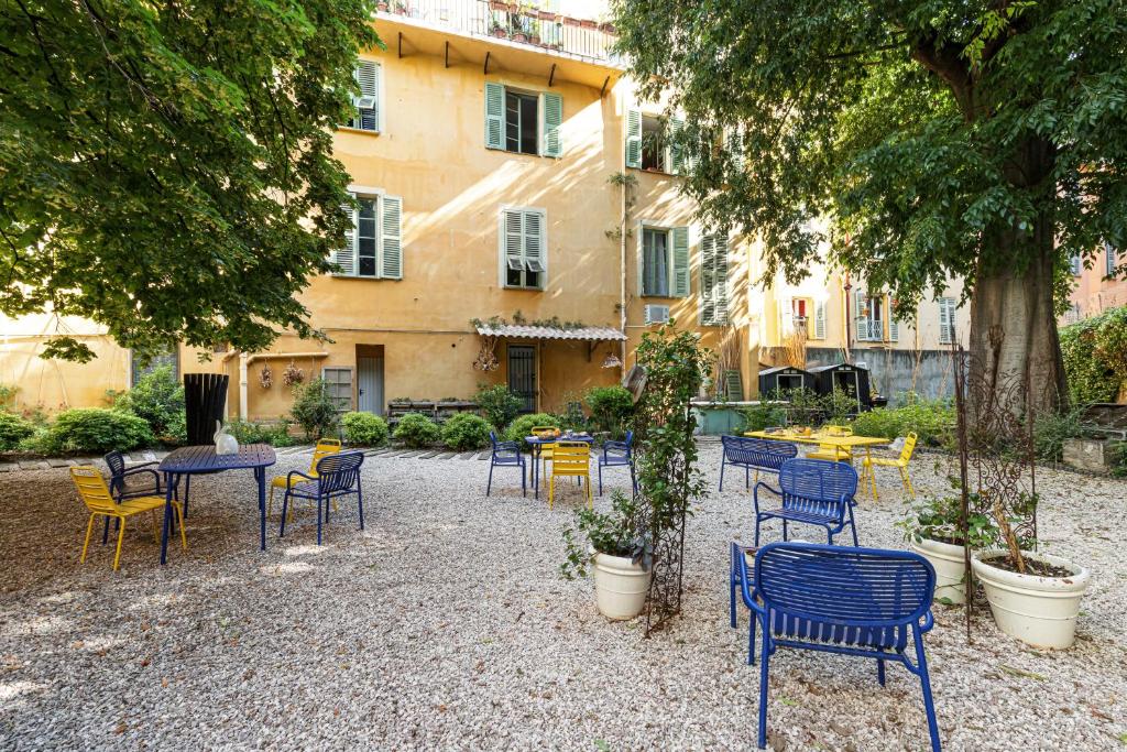 a patio with chairs and tables and a building at L'Abeille - Boutique Apartments in Nice