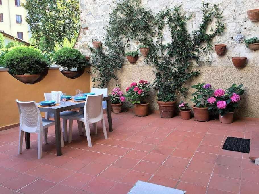 un tavolo e sedie su un patio con piante in vaso di Santa croce elegant with garage a Firenze