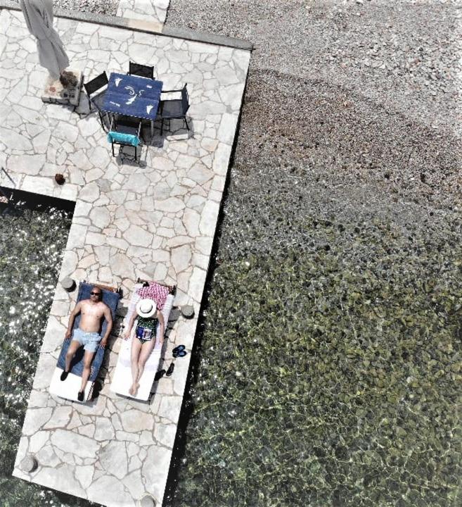 an aerial view of a man sitting on a patio at Symi . VILLA CALME (Sur la Mer). in Symi