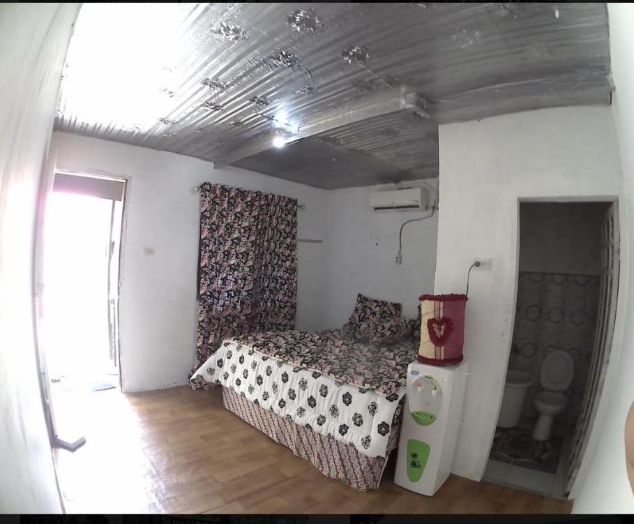 niewielka sypialnia z łóżkiem i oknem w obiekcie CHEAPEST Bungalow AC ROOM w mieście Sabang