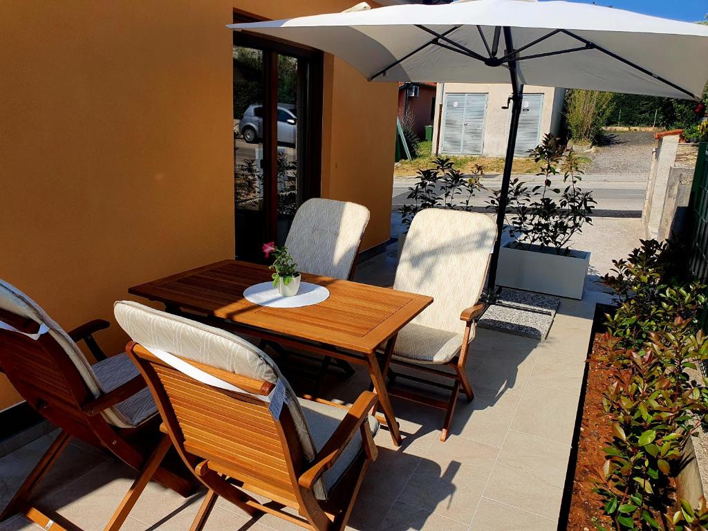 een tafel en stoelen met een parasol op een patio bij Apartment Blue Pula, New, Family friendly, Comfortable, free parking and WiFi in Pula