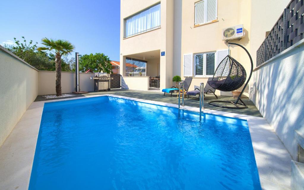 una grande piscina blu davanti a una casa di Apartment NB a Šilo