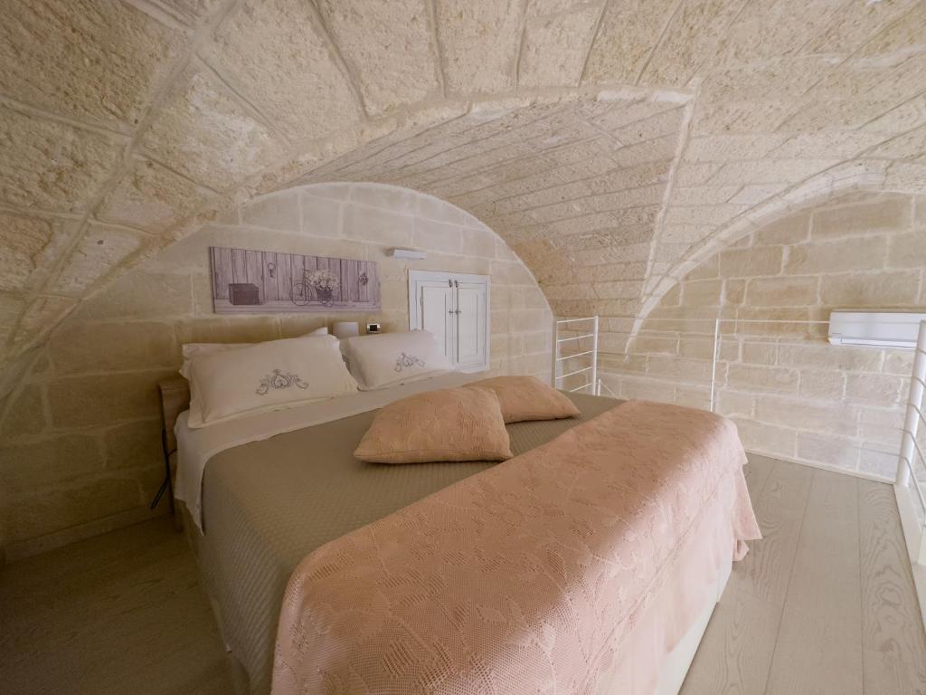 a bedroom with a large bed in a stone wall at Antica Cisterna di Lecce in Lecce