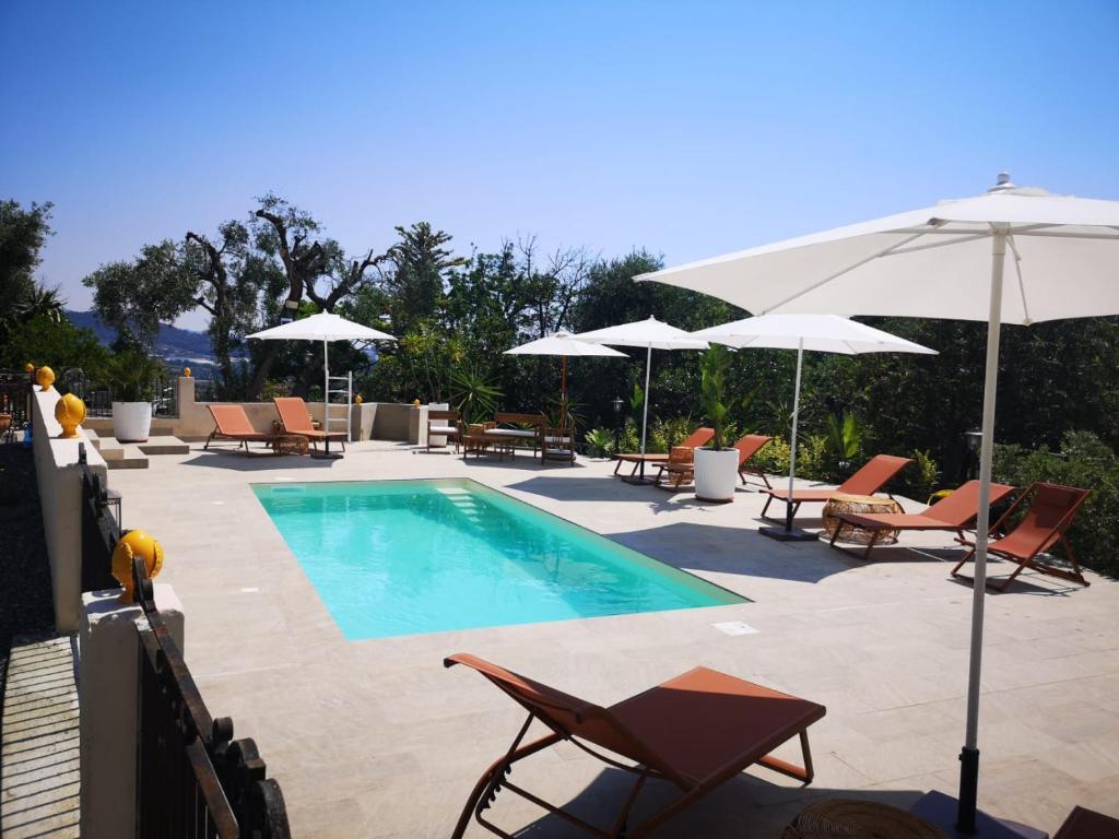 a swimming pool with chairs and umbrellas at Peiranze144 b&b in Sanremo