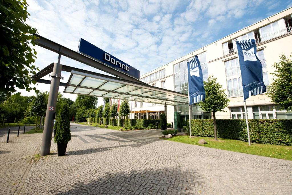 a building with blue flags in front of a building at Dorint Sanssouci Berlin/Potsdam in Potsdam