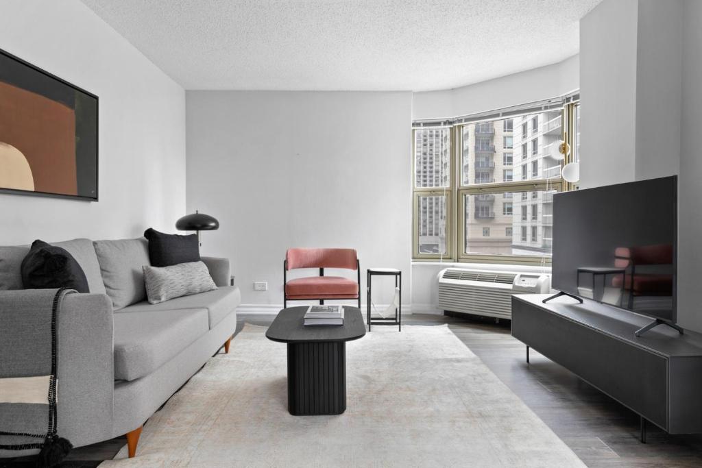 a living room with a couch and a chair at Gold Coast 1BR w Deck Gym Lounge 1 block to L CHI-650 in Chicago