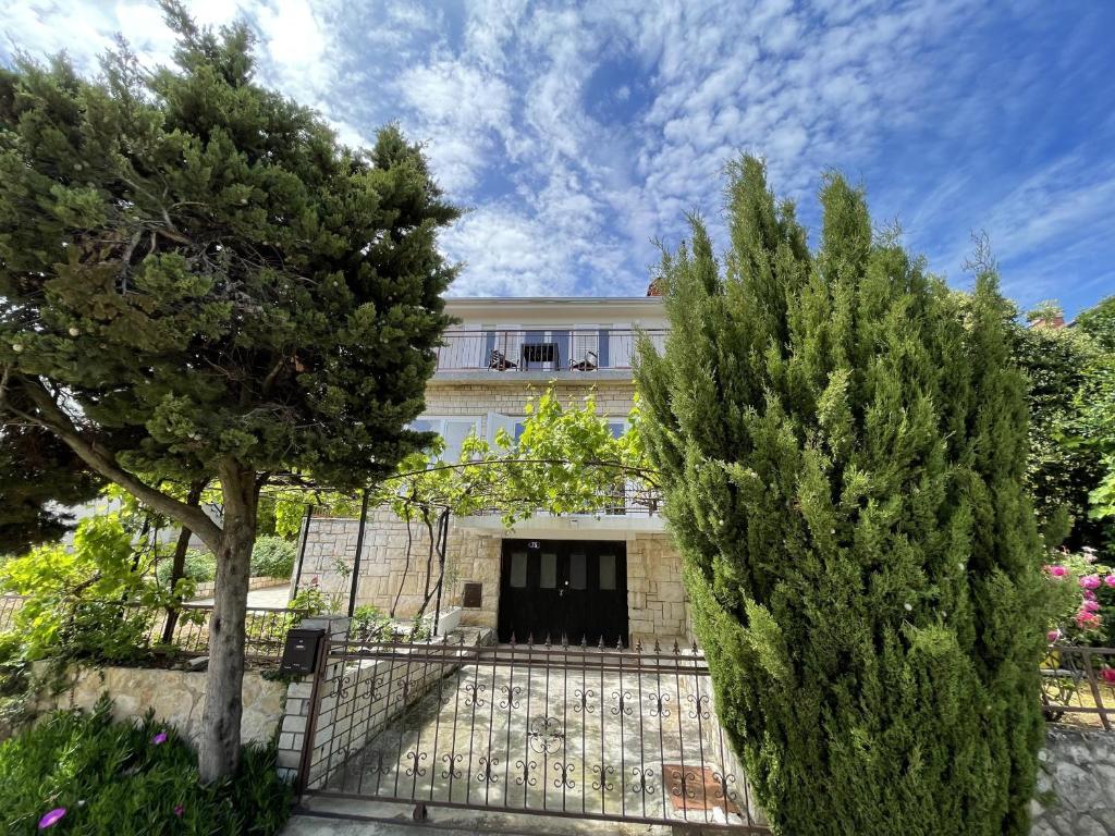 a house with a fence and two trees at Apartment Tulip in Premantura