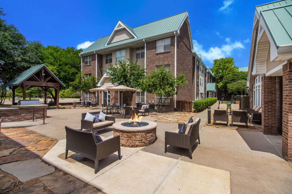a patio with chairs and a fire pit in front of a building at Sonesta ES Suites Dallas Richardson in Richardson