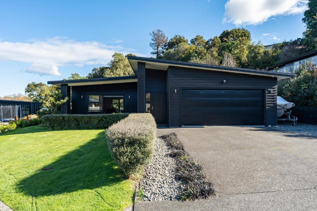 a house with a garage in a yard at Riverside in Taupo