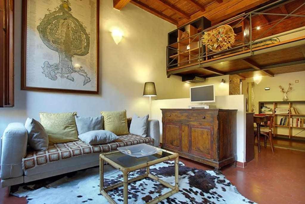 フィレンツェにあるTwo Bedrooms Apartment Near The Duomo Firenzeのリビングルーム(ソファ、テーブル付)