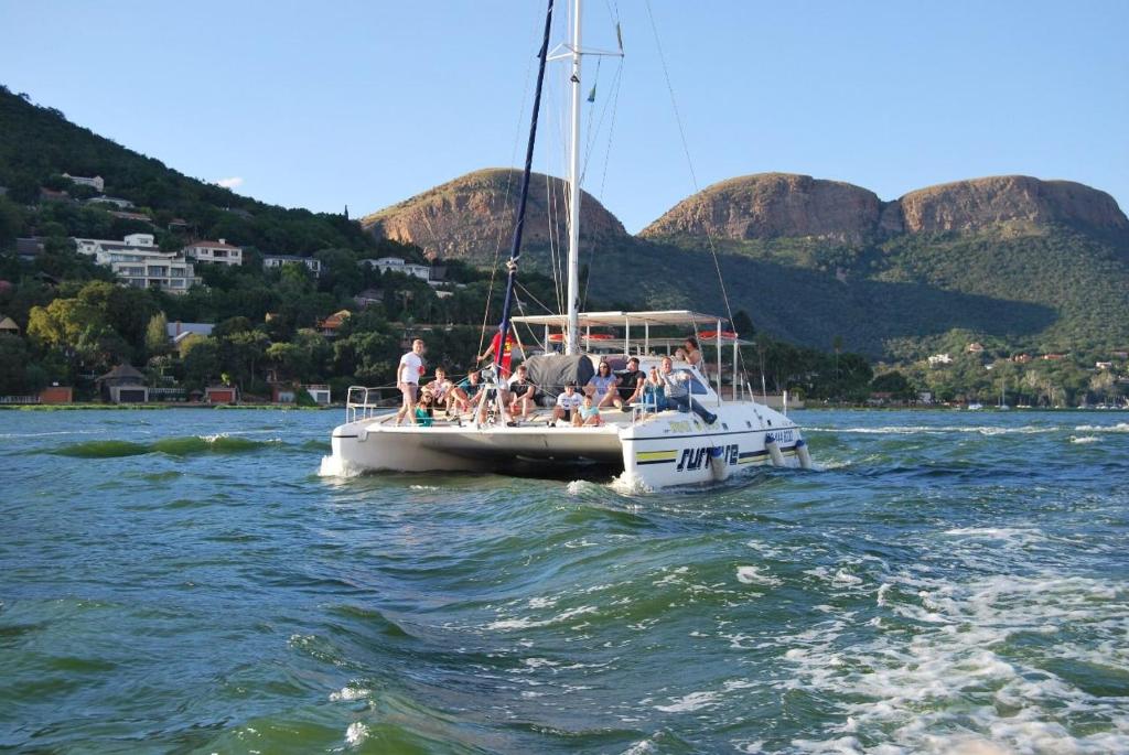 un grupo de personas en un barco en el agua en Wildcat Catamaran Cruises en Hartbeespoort