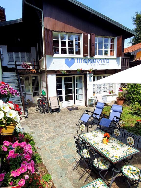 a patio with a table and chairs in front of a building at Villanuvola in Meina