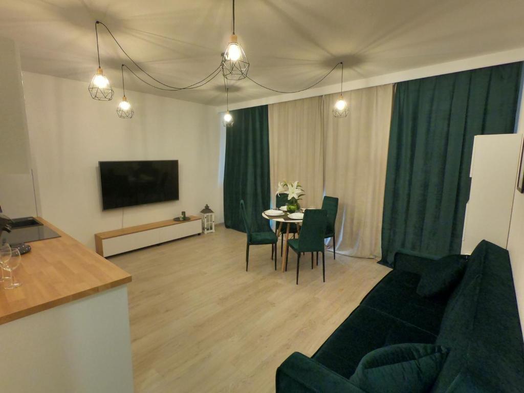 ein Wohnzimmer mit einem Sofa und einem Tisch mit Stühlen in der Unterkunft Green Sea Gdańsk in Danzig