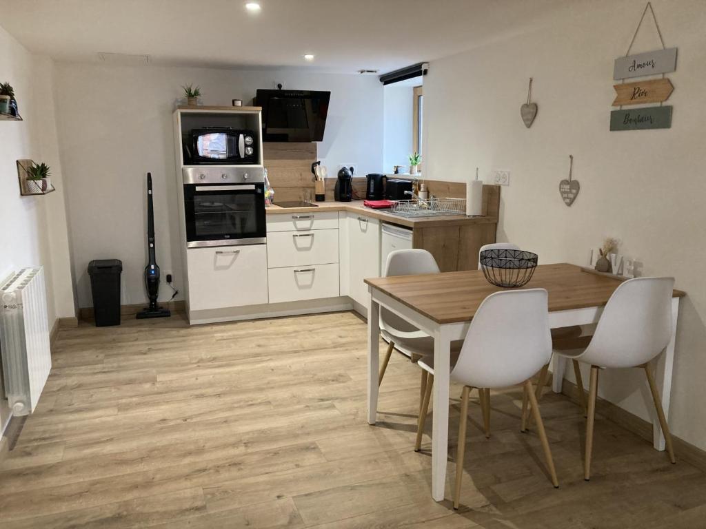 eine Küche mit einem Holztisch und weißen Schränken in der Unterkunft Appartement au cœur d'Espalion Le Perchoir du Lot in Espalion