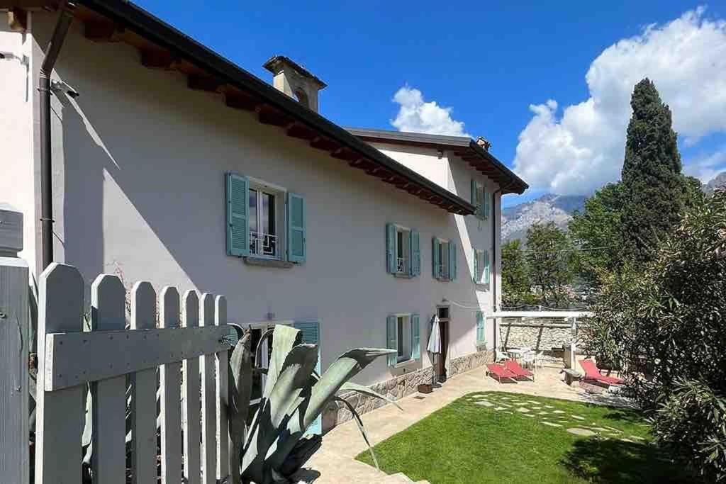 ein weißes Haus mit einem Zaun und einem Hof in der Unterkunft Villa Anna Onno Lake Como in Onno