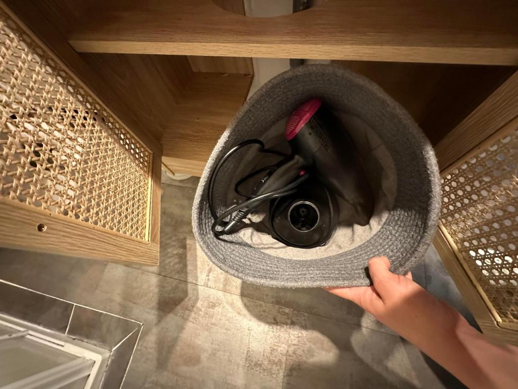 a person is holding a vacuum in a kitchen at Charmant studio lumineux Florida plage in Canet-en-Roussillon