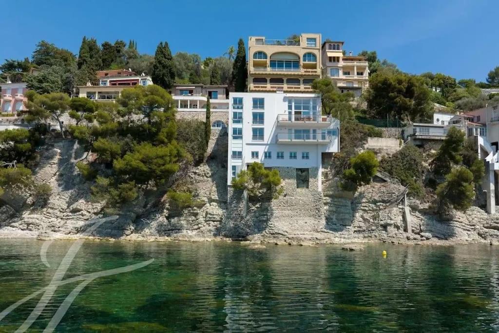 une maison sur une colline à côté de l'eau dans l'établissement Villa Mariella, à Saint-Jean-Cap-Ferrat