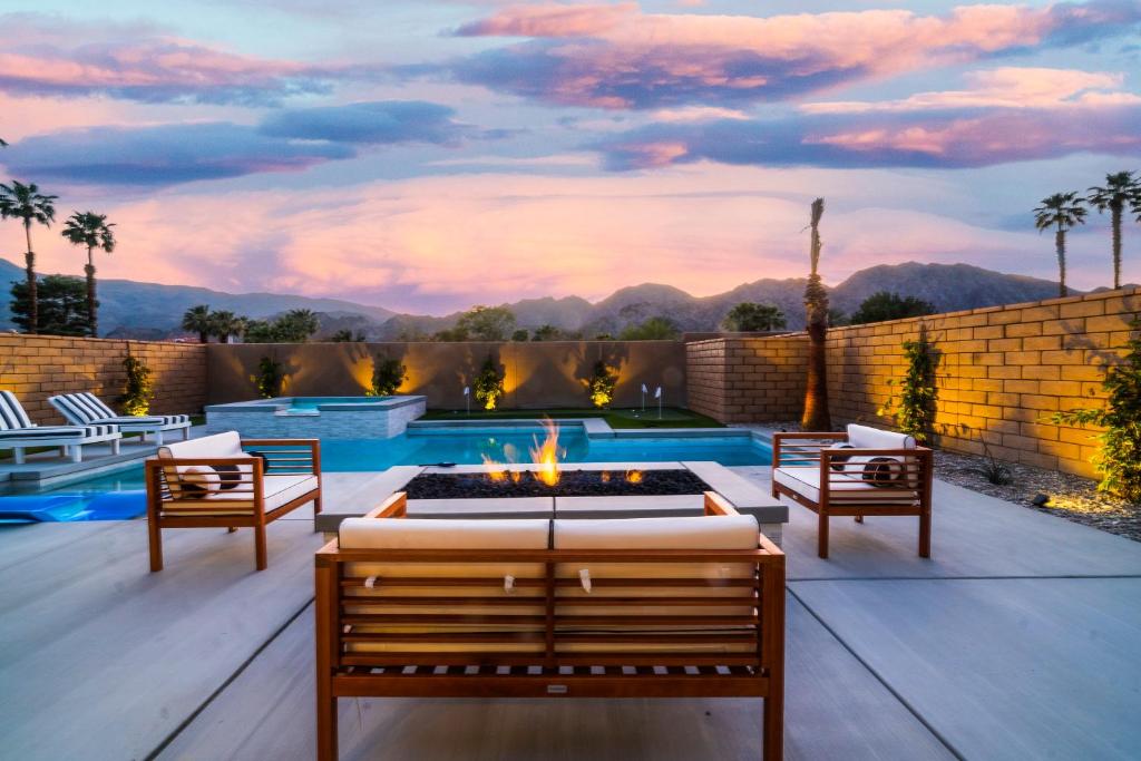a patio with a fire pit and a swimming pool at Spectacular PGA West New Home! in La Quinta