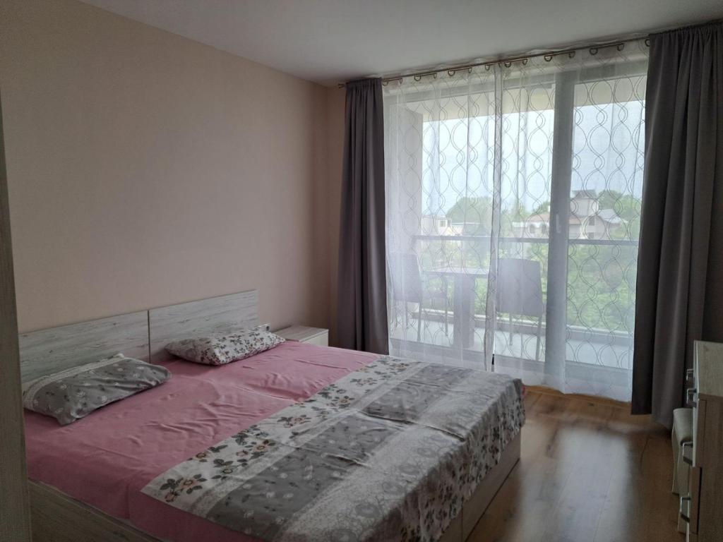 ein Schlafzimmer mit einem Bett und einem großen Fenster in der Unterkunft Апартамент Deluxe 6 in Sweti Konstantin