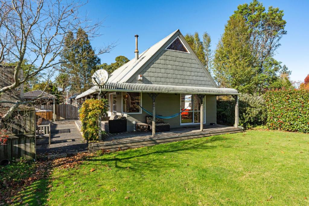 a small house with a porch and a yard at Moore in Turangi in Turangi