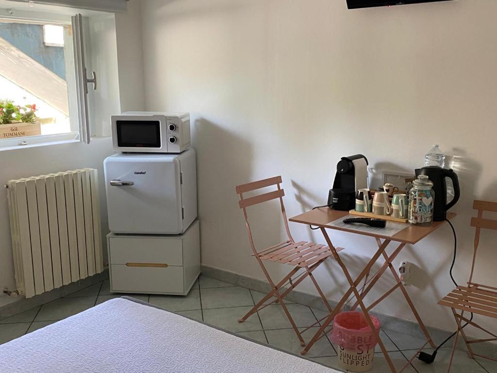 kuchnia ze stołem i kuchenką mikrofalową na lodówce w obiekcie Bonsai - Bed & Breakfast w mieście Pesaro