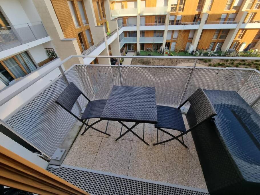 a balcony with a table and chairs on a patio at Appart neuf entre Paris et Versailles, A 5 mn école Ducasse in Meudon