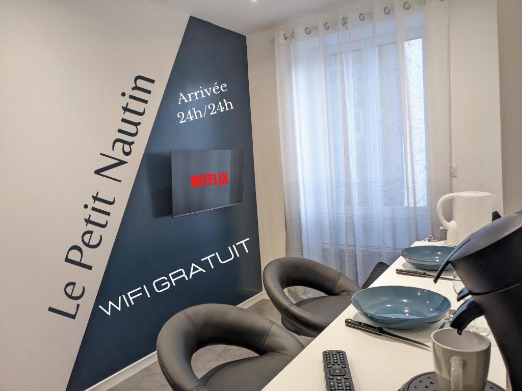 une salle de réunion avec des chaises et un panneau pour un événement dans l'établissement Le Petit Nautin centre ville Saint-Etienne, à Saint-Étienne