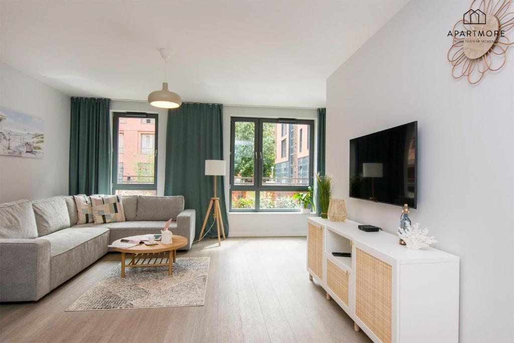 a living room with a couch and a tv at City Center - Długa Grobla by Apartmore in Gdańsk