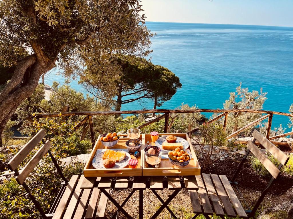 una mesa con comida en ella con el océano en el fondo en Eufonia del Mare en Finale Ligure