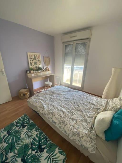 a bedroom with a bed and a desk and a window at Grand appartement F3 - Centre- ville Le Bourget in Le Bourget