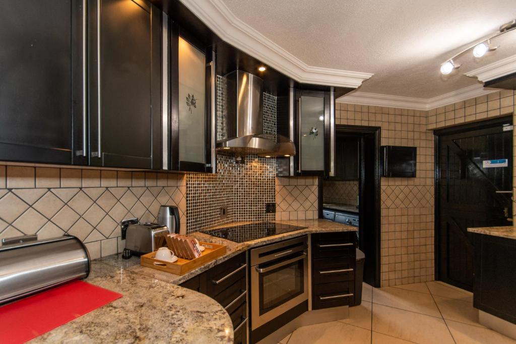 a kitchen with black cabinets and a counter top at Kruger Park Lodge Unit No. 209 in Hazyview