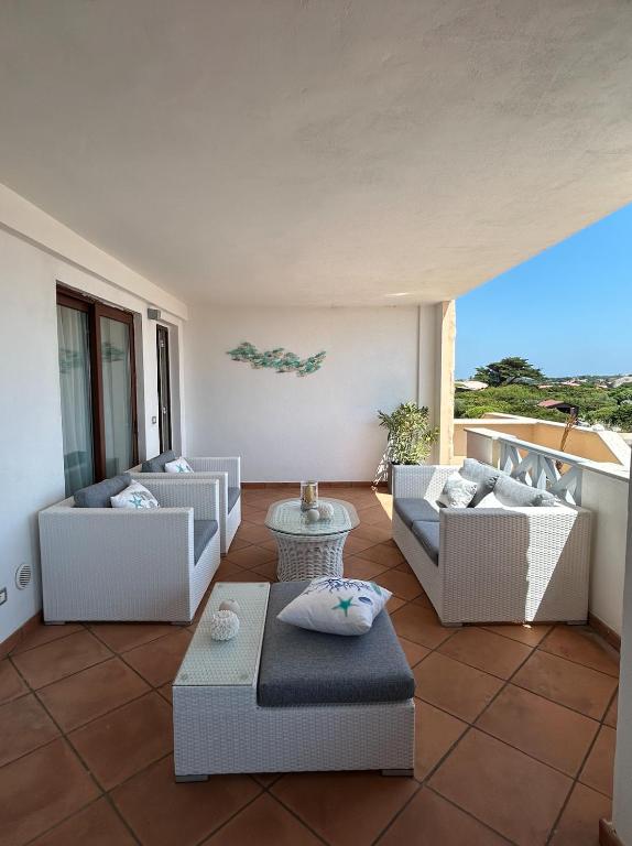 d'un salon avec un mobilier blanc et une vue sur l'océan. dans l'établissement CAMARU CANTU, à Bonifacio