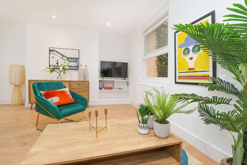 ein Wohnzimmer mit einem grünen Stuhl und einem Couchtisch in der Unterkunft Luxury interior designed 1 bed in London
