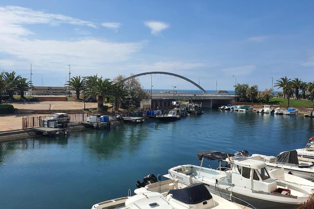 a group of boats docked in a river with a bridge at Charmant 2 pièces, Vue sur Mer - Proche Plage in Sète