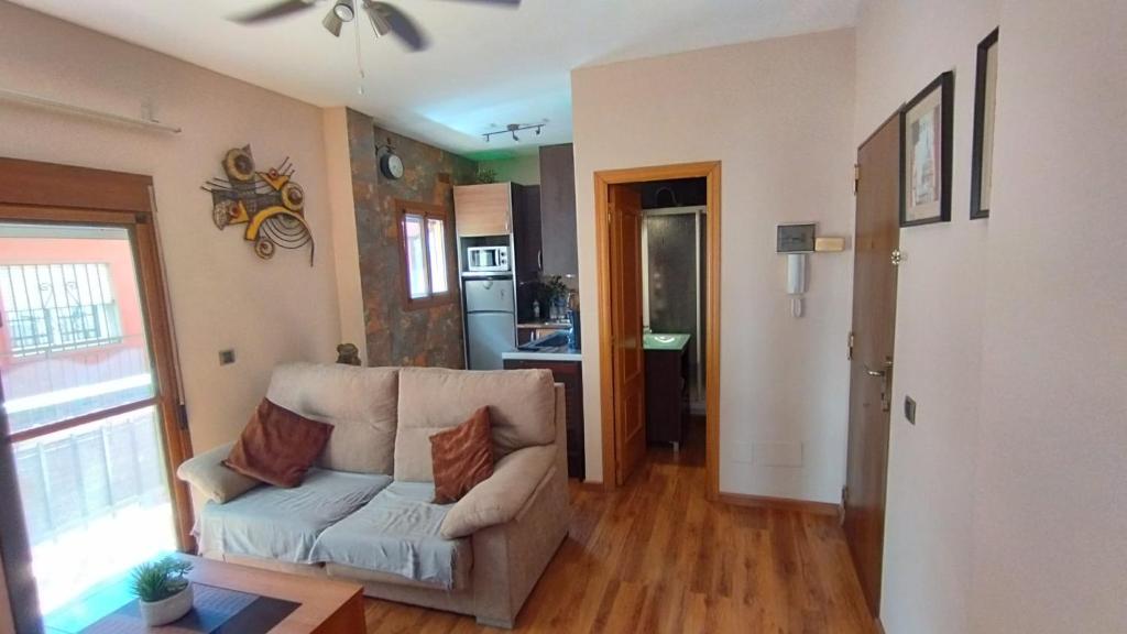 een woonkamer met een bank en een keuken bij Piso playa centro fuengirola in Fuengirola