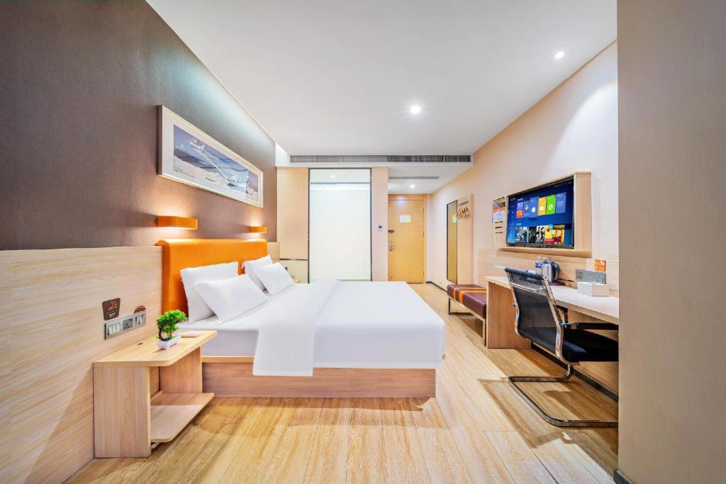 um quarto de hotel com uma cama e uma televisão em 7 Days Premium - Kunming South High Speed Railway Station University Town Metro Station em Kunming