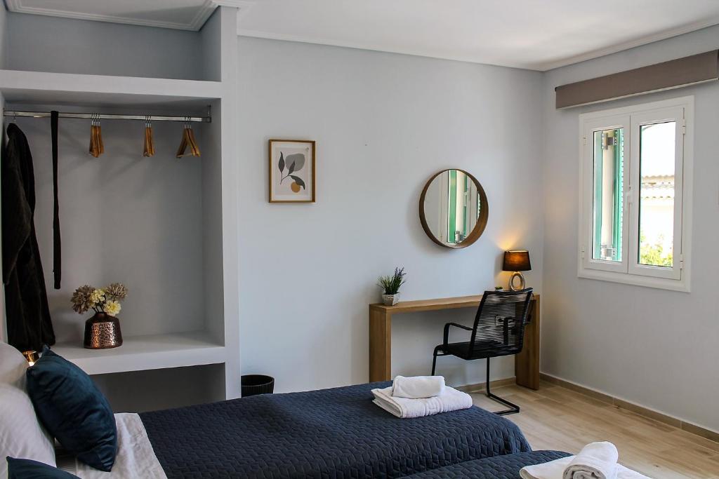Un dormitorio con una cama azul y un espejo. en Wave Luxury Apartments, en Kassiopi