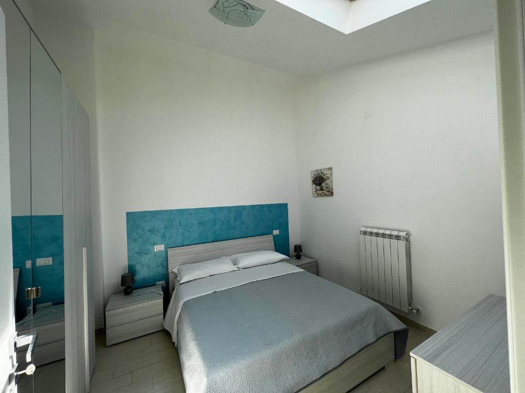 a bedroom with a large bed with a blue headboard at Nautilus Appartamenti a mare in Ortona