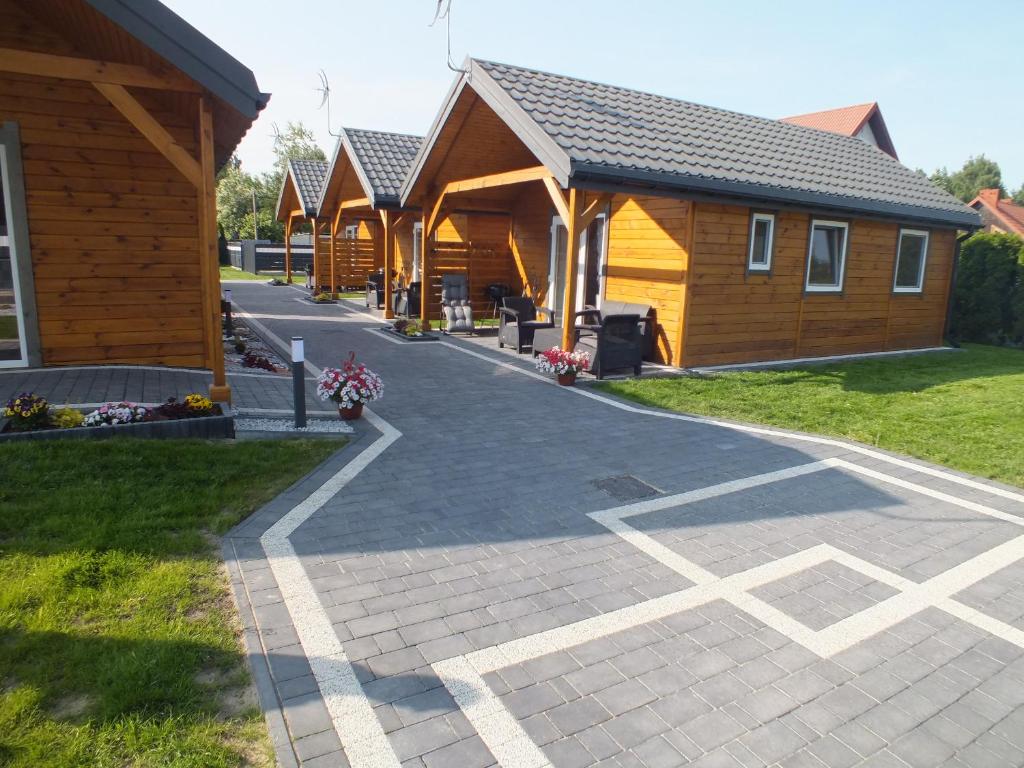 une rangée de cabines en bois dans l'établissement Domki letniskowe- Magnoliowa przystań, à Firlej