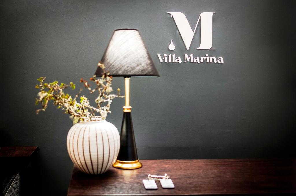 una lámpara sentada en una mesa junto a un jarrón en Villa B&B Marina & Parking Free, en Rovinj