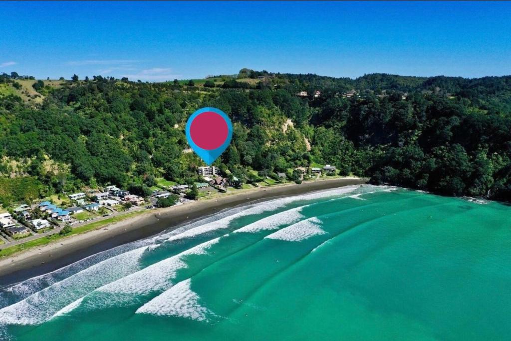 a blue and red balloon flying over a body of water at West End private apartment in Ohope Beach