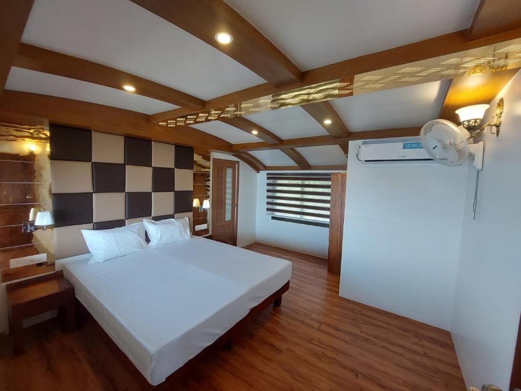 a bedroom with a white bed and a checkered wall at Premium Houseboat in Alleppey