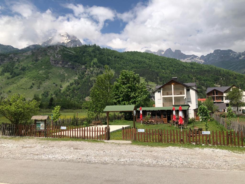 una casa con una valla delante de una montaña en Guesthouse HYSA, en Valbonë
