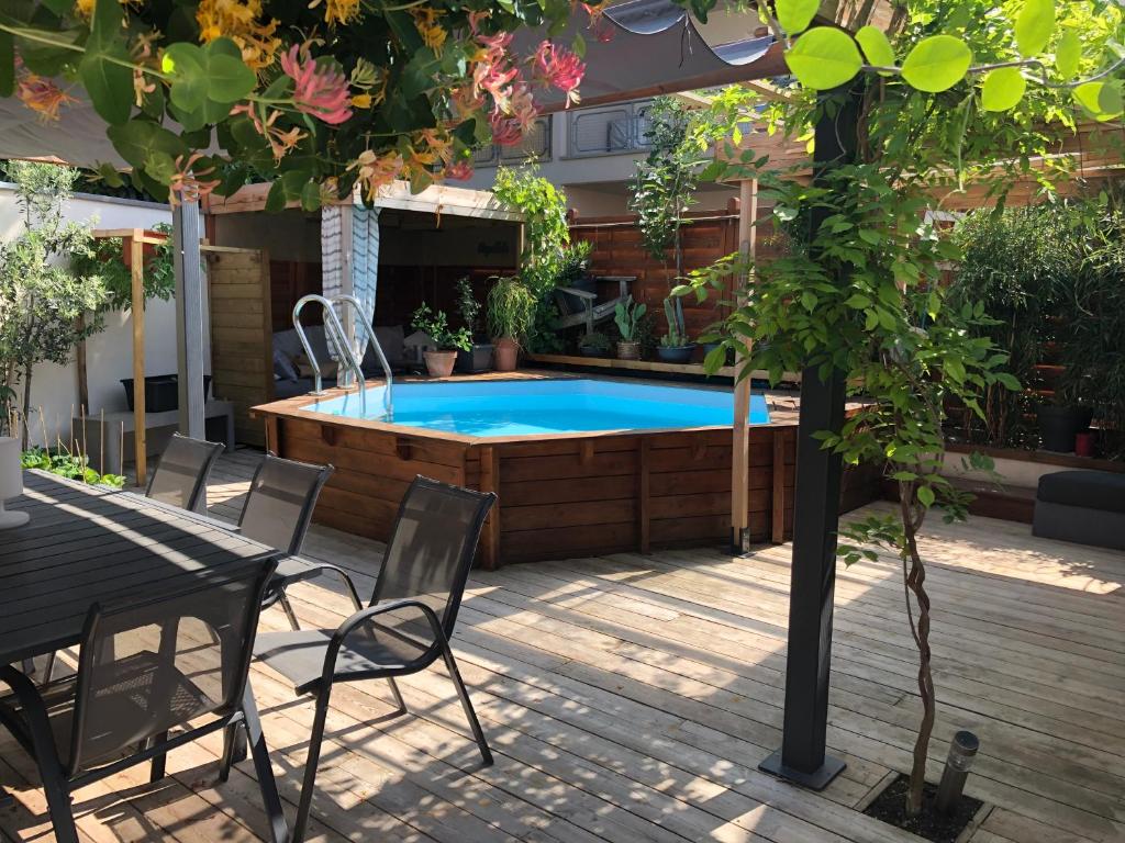 een hot tub in een patio met een tafel en stoelen bij cocooning in Rumersheim-le-Haut