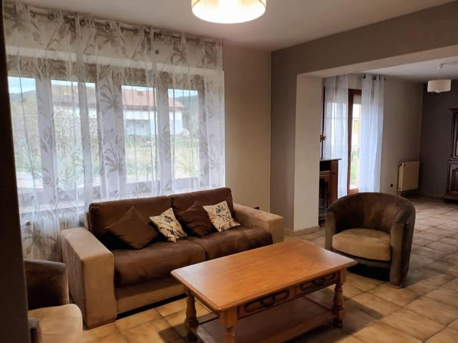 ein Wohnzimmer mit einem Sofa und einem Couchtisch in der Unterkunft Maison familiale au coeur des Vosges in Aumontzey