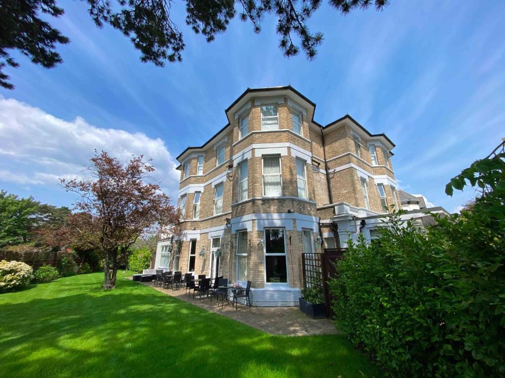 a large brick house with a green lawn at Applewood Hotel in Bournemouth