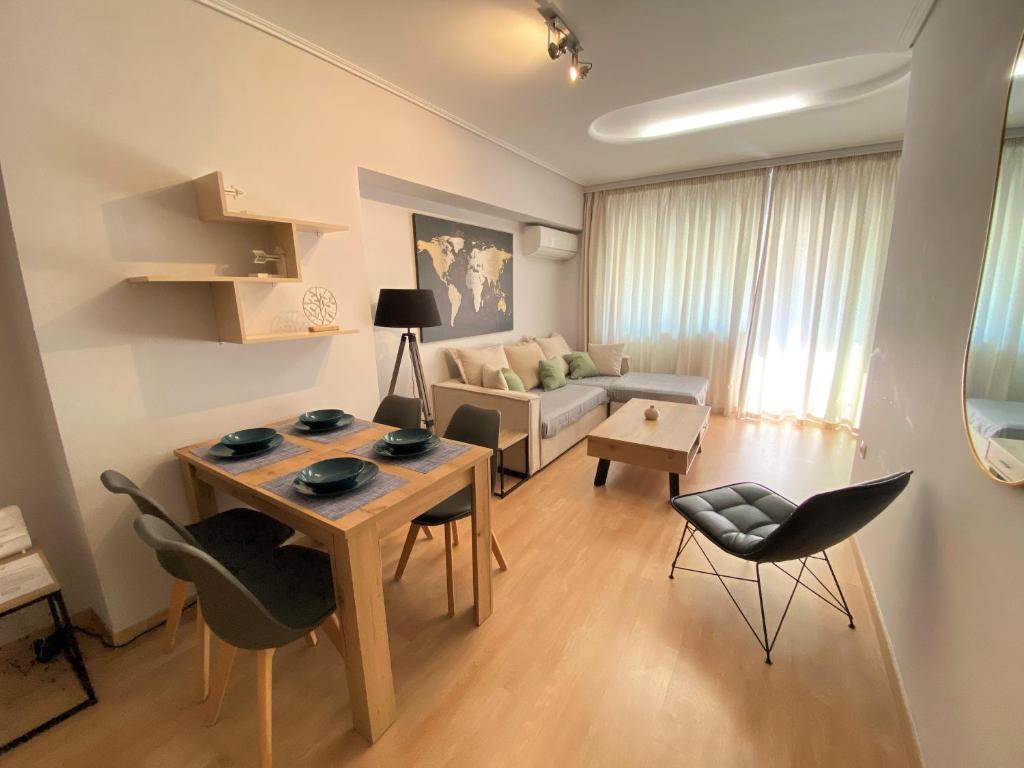 a living room with a table and chairs and a couch at Spetson Modern 56sqm apt in Piraeus in Piraeus