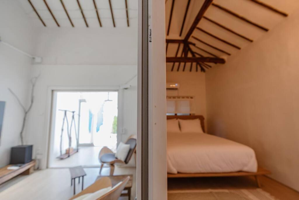 sypialnia z łóżkiem i pokój z oknem w obiekcie Spring Day w mieście Jeonju
