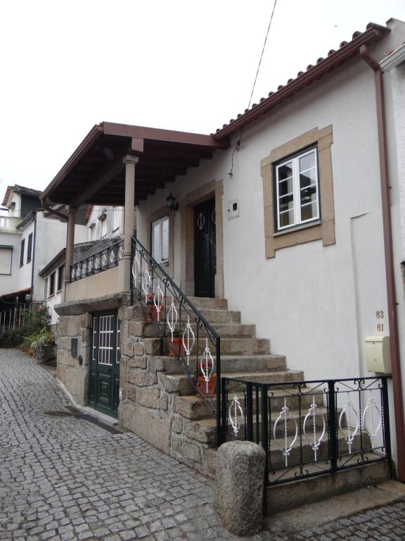 une maison blanche avec des escaliers, une fenêtre et une porte dans l'établissement Casa Luizinho, à Seixo da Beira