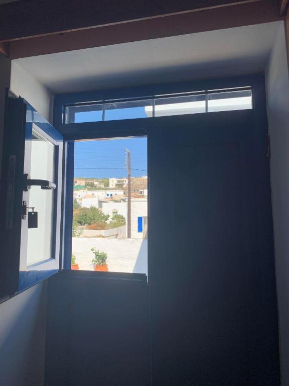 eine Tür in einem Zimmer mit Fenster in der Unterkunft Stefanoula's house in Kimolos
